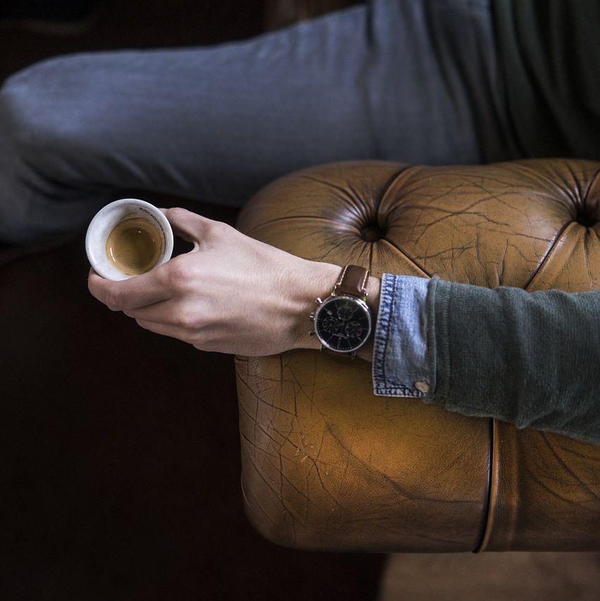 Mand med kaffekop i lænestol