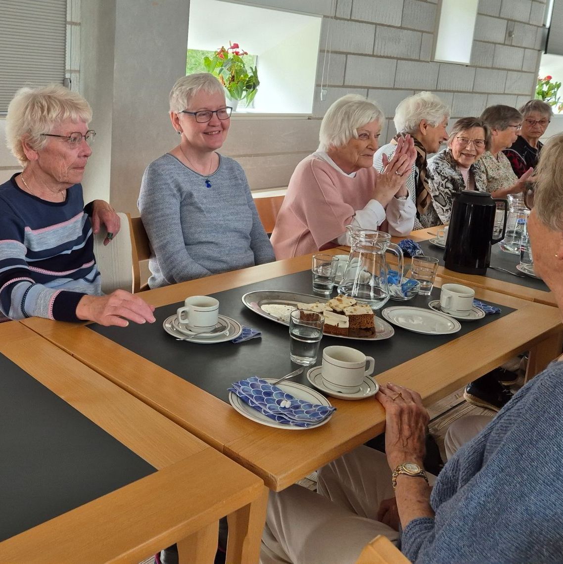 Damer i fællesskab, spiser kage og drikker kaffe